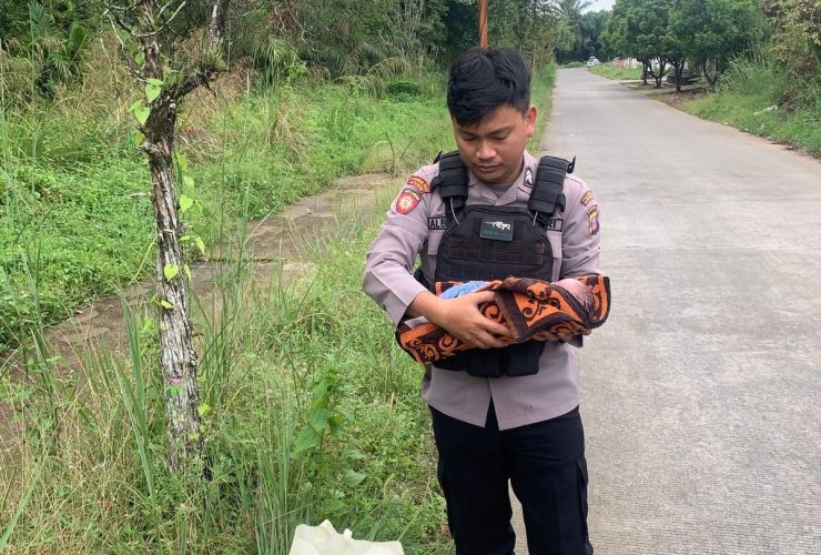 (Foto: Pihak kepolisian saat mengamankan bayi yang dibuang di pinggir jalan/Ist)